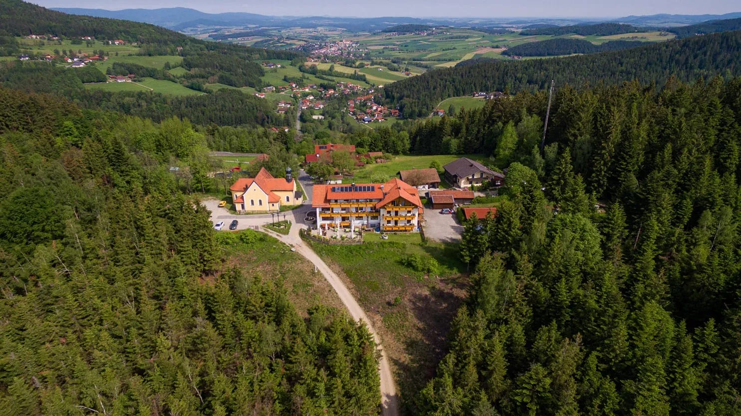 Luftbild des Kolmsteiner Hofs mit Wallfahrtskirche, Zufahrt und Blick ins Tal nach Neukirchen b. Hl. Blut