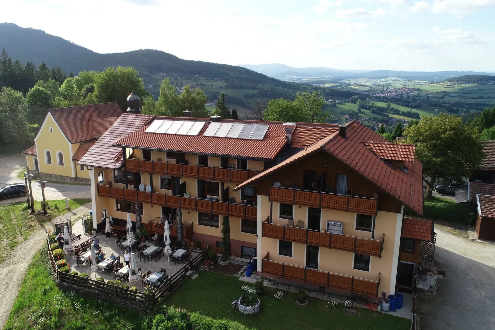 Der Kolmsteiner Hof von oben — Pension mit Balkonen, Terrasse und Blick über den Bayerischen Wald